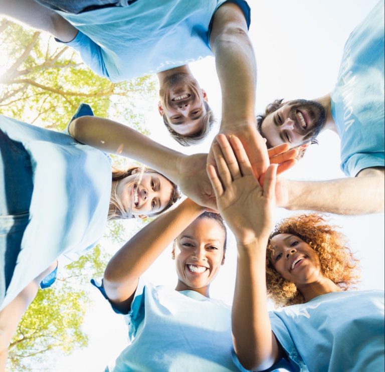 Portrait of volunteer group forming huddles